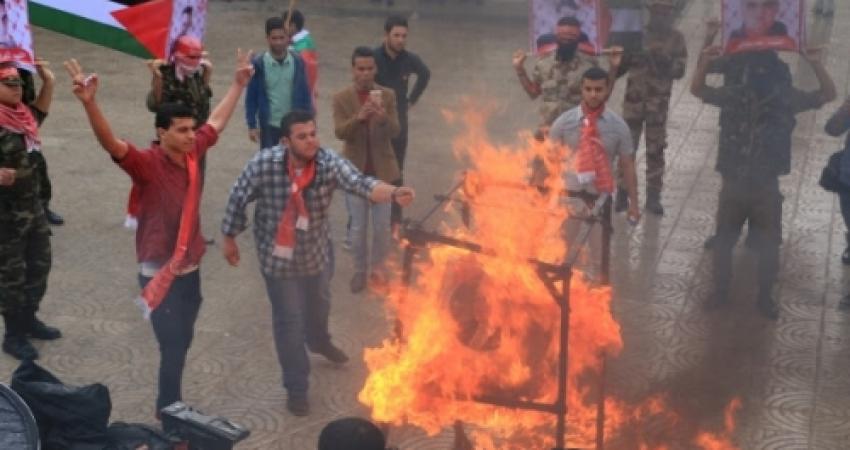 عناصر من الجبهة الشعبية يحرقون صور عباس في غزة