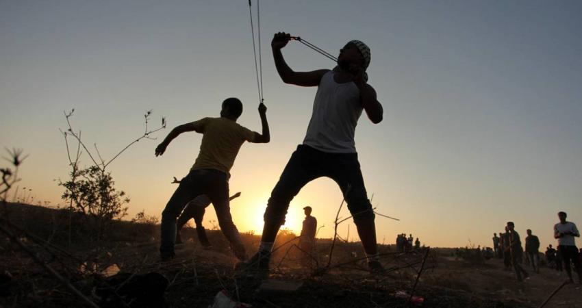 شبان فلسطينيين يلقون الحجارة