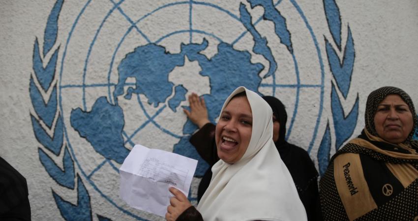 A-Palestinian-woman-holds-her-refugee-ration-card-during-a-protest-demanding-the-United-Nations-Relief-and-