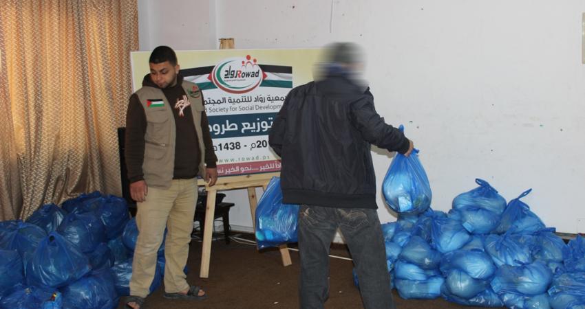 "روّاد" توزيع عشرات الطرود الغذائية للأسر المتعففة بغزة