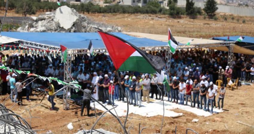 أهالي قلنديا يؤدون صلاة الجمعة بجانب أنقاض المنازل المهدمة