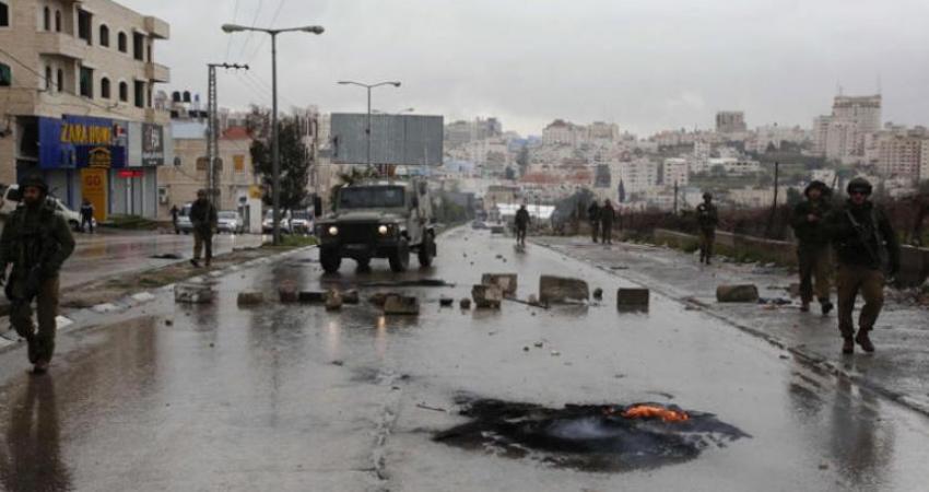 جنود إسرائيليون خلال مواجهات مع فلسطينيين في حلحول شمال الخليل بعد تشييع جثمان حمزة زماعرة  (أ.ف.ب)