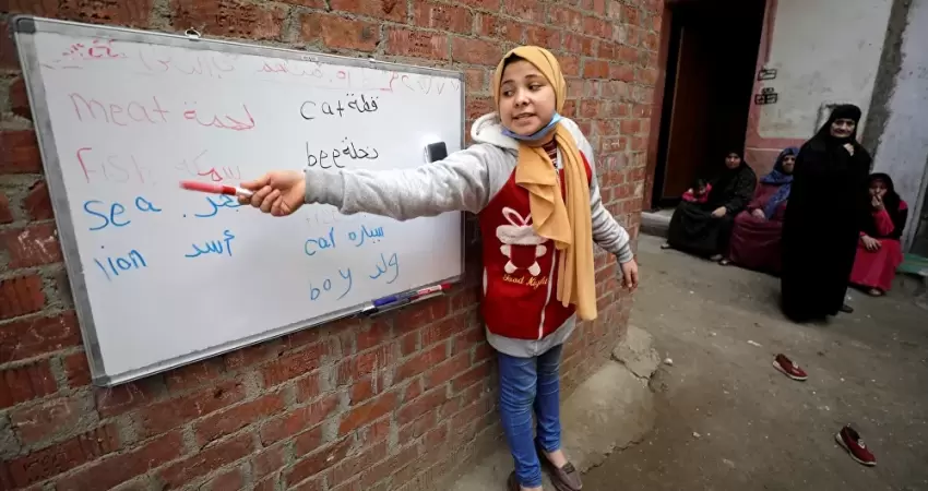 تلميذة صغيرة تصبح معلمة كبيرة في أحد أحياء مصر